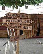 Ce panneau disposé à l'entrée indique les directions de grandes villes : Tombouctou, macondo, samarkand
